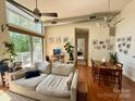 Bright living room featuring high ceilings, expansive windows, and an adjacent dining area at 2116 Mcclintock Rd # 123, Charlotte, NC 28205