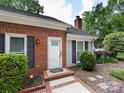 Brick home featuring front door with decorative shutters and well-maintained landscaping at 2502 Breuster Dr, Charlotte, NC 28210