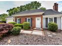 Brick home featuring manicured landscaping, a white front door, and dark shutters at 2502 Breuster Dr, Charlotte, NC 28210