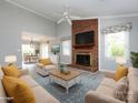 Living room featuring a brick fireplace, large windows, and neutral-toned furniture at 2502 Breuster Dr, Charlotte, NC 28210
