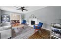 Cozy living room with hardwood floors, a fireplace, and an open layout connecting to the dining area at 2626 Lilly Mill Rd, Charlotte, NC 28210