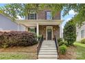 Beautiful brick home featuring a covered front porch with white columns and concrete steps with a metal railing at 2638 Double Oaks Rd, Charlotte, NC 28206
