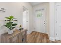 Bright foyer with wood flooring, a decorative table with plant, and a door with decorative glass panels at 2638 Double Oaks Rd, Charlotte, NC 28206