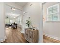 Bright hallway with wood floors, decorative table with a plant, and an open view into the dining and living area at 2638 Double Oaks Rd, Charlotte, NC 28206