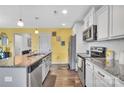 Bright kitchen features a granite countertop island, stainless steel appliances, and wood grain floors at 3578 Saddlebrook Dr, Midland, NC 28107