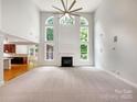 Bright living room with tall ceilings, a ceiling fan, a fireplace and large windows with natural light at 3904 Hounslow Ln, Harrisburg, NC 28075