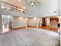 Spacious living room showcasing open floorplan, high ceilings, and hardwood floors leading to the kitchen and entryway at 3904 Hounslow Ln, Harrisburg, NC 28075