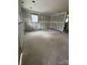 Unfinished living room with a doorway leading to another room, ready for remodeling at 411 Woodlawn Ave, Gastonia, NC 28052