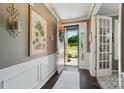 Elegant foyer with hardwood floors, white wainscoting, and an open view to the landscaped front yard at 475 Hunton Forest Nw Dr, Concord, NC 28027
