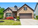 Charming brick home featuring a two-car garage and inviting front yard with colorful landscaping at 475 Hunton Forest Nw Dr, Concord, NC 28027