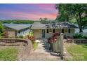 Charming home with beautiful landscaping, including red roses and a glimpse of the lake at sunset at 4960 Longfield St, Claremont, NC 28610