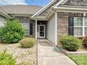Close-up of the home's entrance, showcasing a brick facade, manicured bushes and walkway at 5355 Hackberry Sw Ln, Concord, NC 28027
