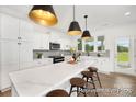 Bright, modern kitchen features a large center island, stainless appliances, and elegant pendant lighting fixtures at 5594-C Galloway Dr # 99P, Stanfield, NC 28163