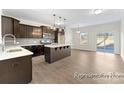 Open-concept kitchen and dining area with dark cabinets, stainless steel appliances, an island, and a sliding door to the backyard at 5634-A Galloway Dr # 96P, Stanfield, NC 28163