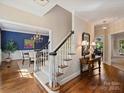 Elegant foyer featuring hardwood floors, staircase, and views into the dining room, exuding classic style at 5917 Summerston Pl, Charlotte, NC 28277