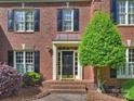Close-up of the home's entry featuring a black front door with detailed trim and professional landscaping at 5917 Summerston Pl, Charlotte, NC 28277