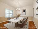 Formally staged dining room features a modern marble table, chandelier, and ample natural light at 720 Kingsmill Ln, Clover, SC 29710