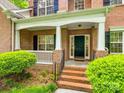 Inviting front porch with white columns, brick steps, and dark green front door at 720 Kingsmill Ln, Clover, SC 29710