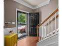 Bright foyer with wood floors, staircase, yellow console, and open view to the outside at 9437 Tavistock Ct, Matthews, NC 28105