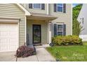Close-up of front entrance featuring black door, house number, and landscaped garden at 9437 Tavistock Ct, Matthews, NC 28105