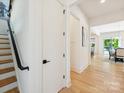 Bright hallway with hardwood floors, a staircase with black metal railing, and views into the dining area at 1009 Belmont Ave, Charlotte, NC 28205