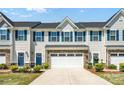 Charming townhome with a two-car garage, blue shutters, and a beautifully landscaped front yard at 10436 Dalton Woods Nw Ct, Huntersville, NC 28078