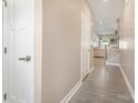 Bright hallway with wood-look floors leading to an open living area with stairs at 10436 Dalton Woods Nw Ct, Huntersville, NC 28078