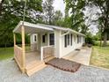 Angle view of house with covered deck, black shutters, and meticulous landscaping around the foundation at 1105 S Church S St, Monroe, NC 28112