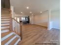 Bright, open-concept living space with wood floors and staircase with wood banister at 11453 Prosperity Church Rd, Huntersville, NC 28078