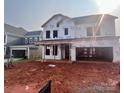 Unfinished two-story home featuring an attached two-car garage and a covered porch at 13251 Chopin Ridge Rd, Huntersville, NC 28078