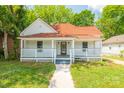 Charming home featuring a welcoming front porch, a red-tiled roof, and a well-maintained lawn at 1712 S Main St, Salisbury, NC 28144