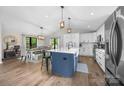 Open kitchen with white cabinets, an island, and a dining area with modern lighting and hardwood flooring at 17403 Green Hill Rd, Charlotte, NC 28278