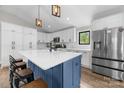 Stylish kitchen with white cabinetry, a blue island with a white countertop, and modern stainless steel appliances at 17403 Green Hill Rd, Charlotte, NC 28278