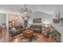 Inviting living room with vaulted ceiling, fan, hardwood floors, and comfortable leather sofas at 1800 Oriole Ct, Monroe, NC 28112