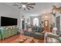 Open-concept living room featuring a ceiling fan, hardwood floors, and comfortable seating arrangements at 1800 Oriole Ct, Monroe, NC 28112