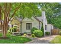 Charming white brick home featuring a quaint front porch and lush landscaping at 2015 Club Rd, Charlotte, NC 28205