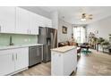 Bright modern kitchen with stainless steel appliances and white cabinetry open to the living room at 2125 Southend Dr # 339, Charlotte, NC 28203