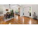 Sunlit dining area with hardwood floors, stylish lighting, and a view to the front yard at 221 Silvercliff Dr, Mount Holly, NC 28120