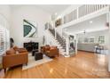 Bright living room showcasing a soaring ceiling, elegant staircase, and hardwood floors at 221 Silvercliff Dr, Mount Holly, NC 28120