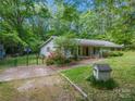 View of home showing stone accents, red shutters, basketball court, landscaping and storage shed at 231 Stockwood Dr, Stanley, NC 28164