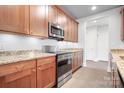 The lovely kitchen offers wood cabinets, granite counters, and stainless steel appliances at 2338 Yadkin Ave # 101, Charlotte, NC 28205