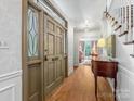 Elegant foyer with hardwood floors, decorative front door, and view to living room at 2501 Richardson Dr, Charlotte, NC 28211