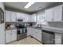 Well-lit kitchen features white cabinets, stainless steel appliances, and granite countertops at 2551 Glenwood St, Kannapolis, NC 28083