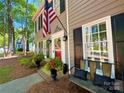 Inviting front porch with a red door, bench seating, potted plants, and an American flag displayed at 2600 Kirkholm Dr, Matthews, NC 28105