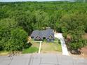 Aerial view of a home nestled amongst mature trees, showcasing its secluded location and long driveway at 2694 Woodcrest Sw Dr, Concord, NC 28027