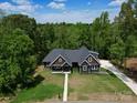 A beautiful single-Gathering home with a lush green lawn and a long driveway surrounded by mature trees at 2694 Woodcrest Sw Dr, Concord, NC 28027