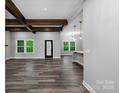 Spacious living room features wood flooring, exposed beams, and a doorway to the kitchen and dining area at 2694 Woodcrest Sw Dr, Concord, NC 28027