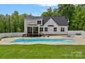 A backyard featuring a swimming pool, white fence, and well-maintained lawn with an extended patio at 270 Worthington Dr, Mt Ulla, NC 28125