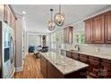 Spacious kitchen with granite countertops, stainless appliances, and dark wood cabinets, open to the living room at 270 Worthington Dr, Mt Ulla, NC 28125