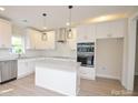 Modern white kitchen featuring a kitchen island, stainless steel appliances and ample storage at 307 N Catawba St, Lancaster, SC 29720